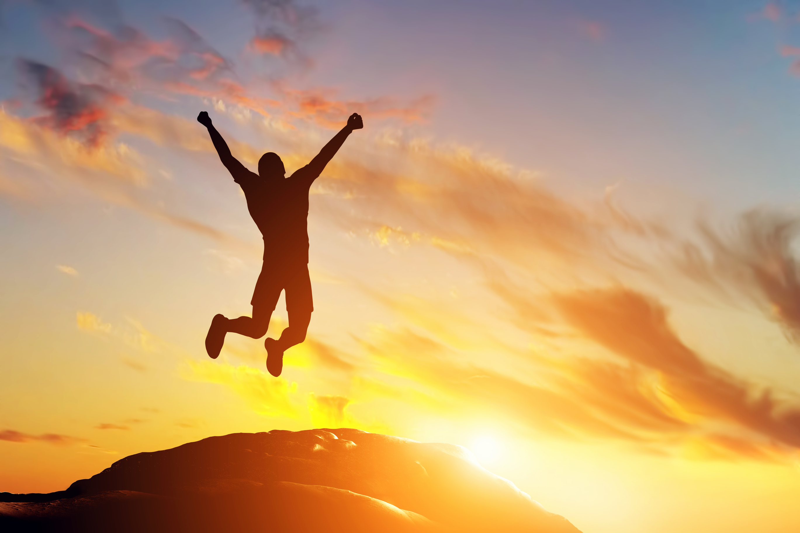 happy-man-jumping-for-joy-on-the-peak-of-the-mountain-at-sunset-success-42811168